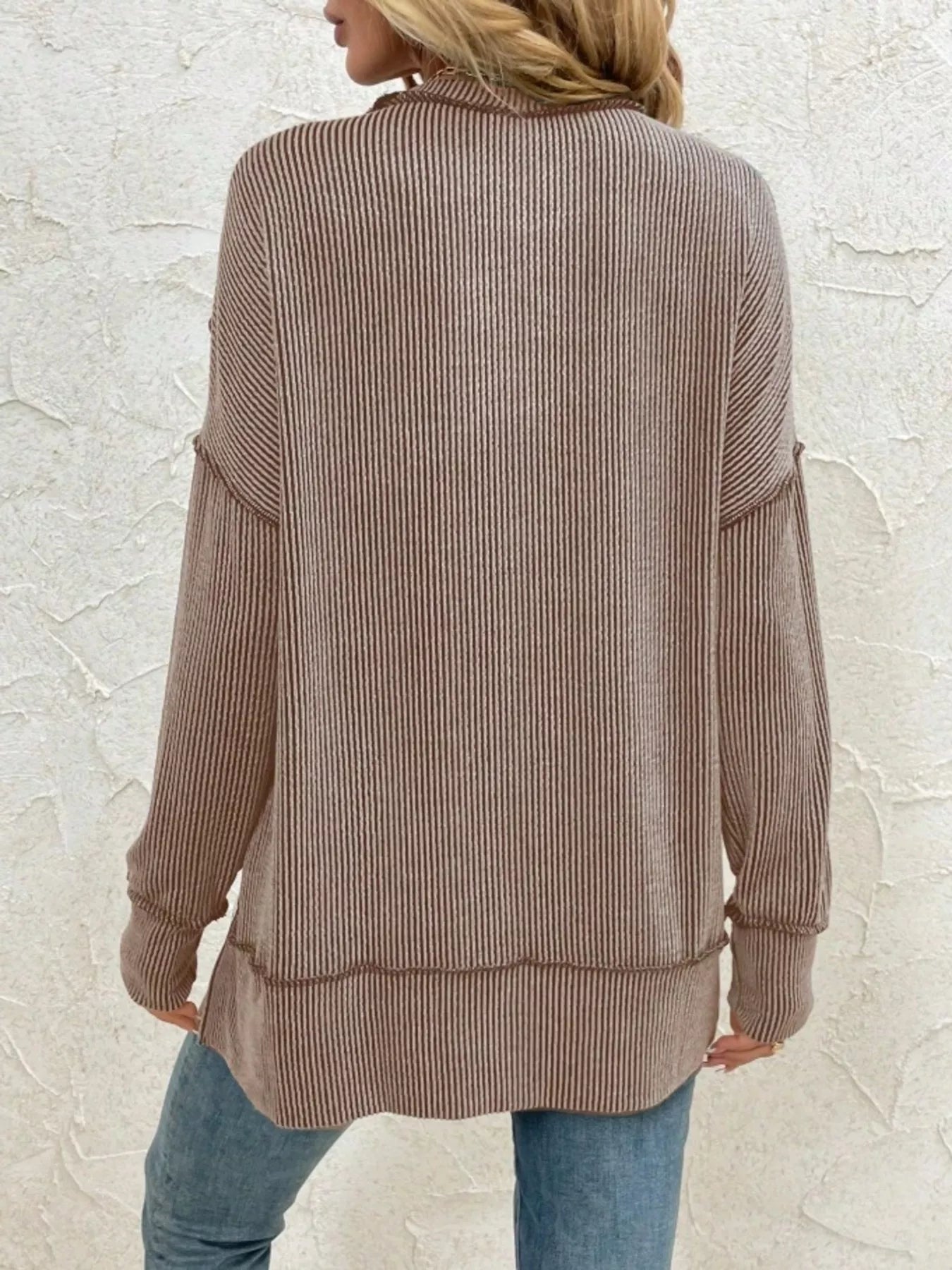 Brown ribbed long sleeve top with relaxed fit, back view, paired with blue jeans for casual style