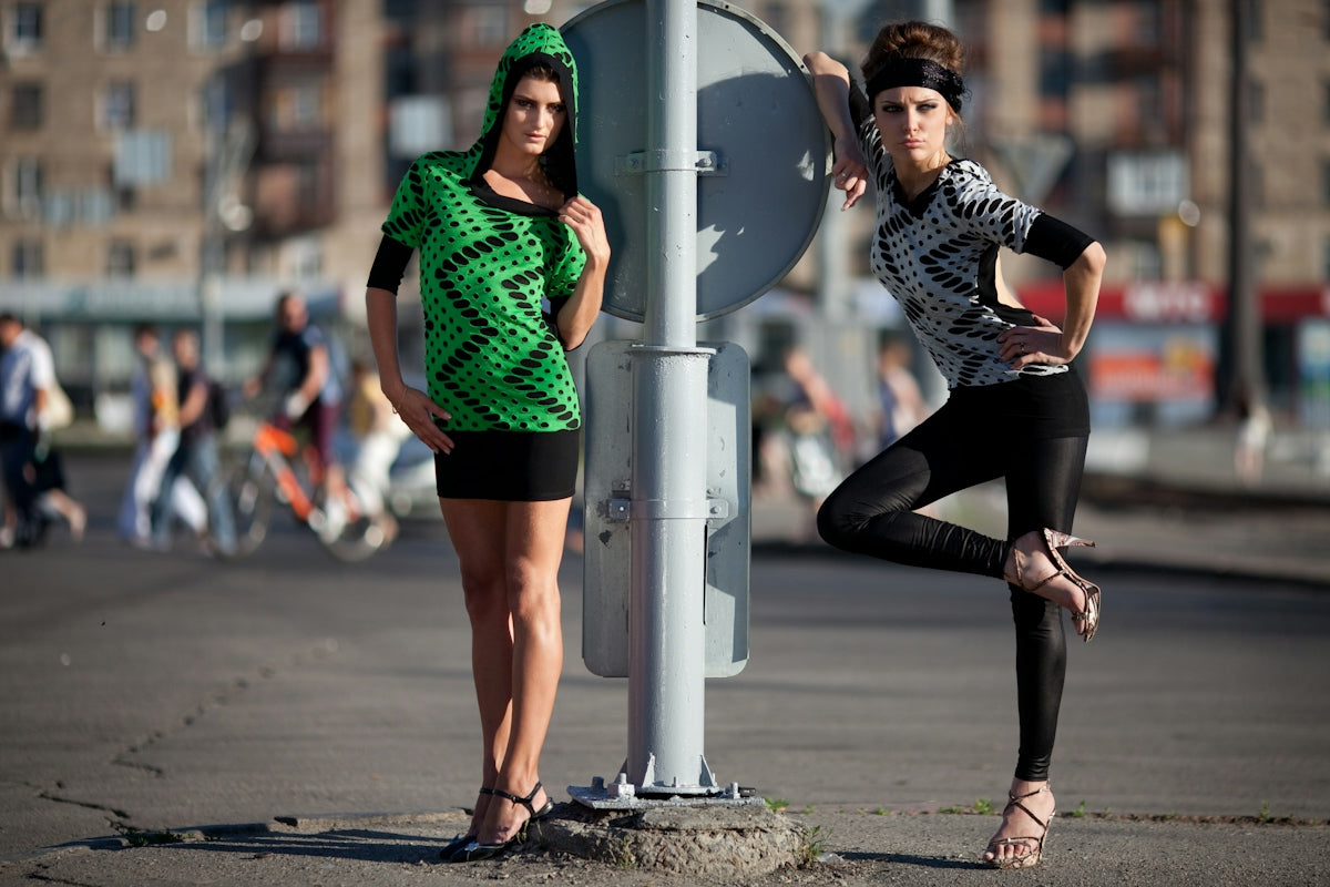 Two fashionable women posing on a city street.
