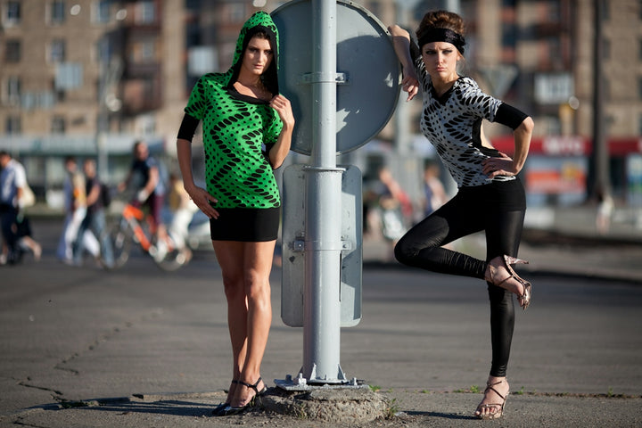 Two fashionable women posing on a city street.