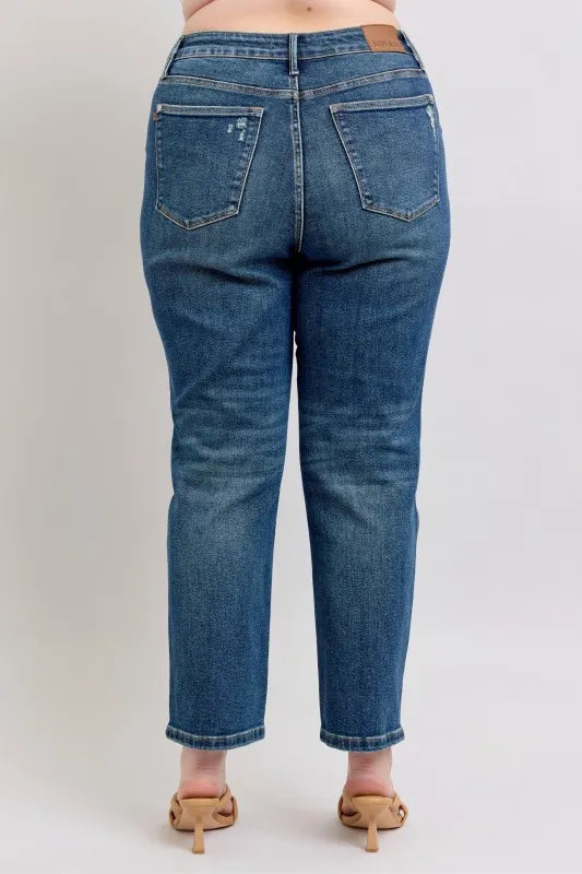 Women's high-waisted straight leg jeans with back pockets, cropped hem, and tan heels