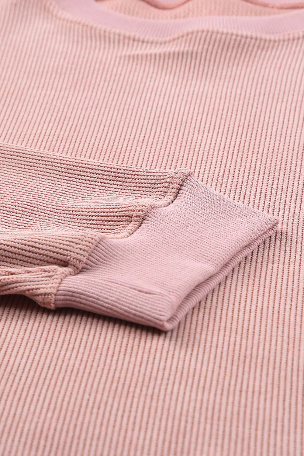 Soft pink ribbed knit top with cozy long sleeves and textured fabric detail