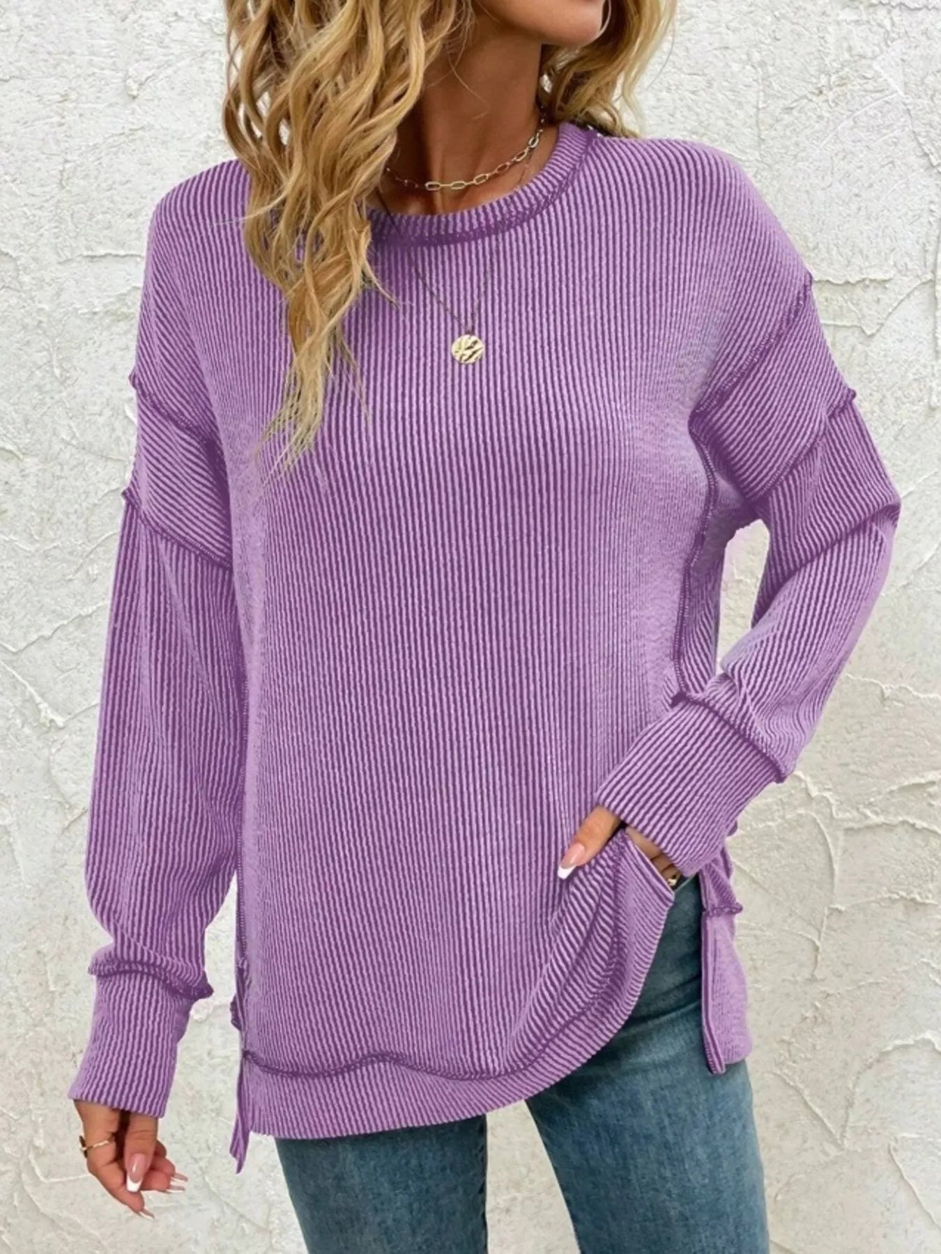 Purple ribbed long sleeve top with side slits, paired with jeans for casual women's fashion