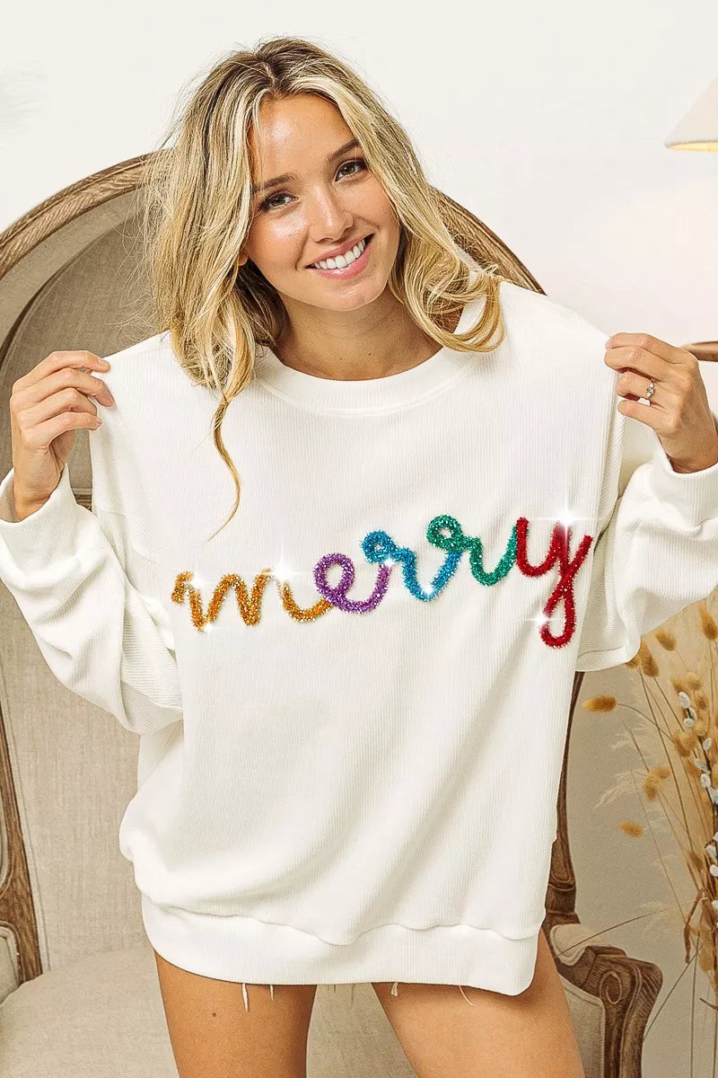 White cozy sweater with colorful 'merry' sequin lettering, perfect for festive women's fashion.