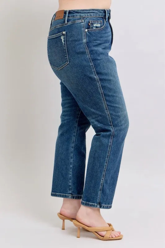 Women's high-waisted flare jeans with distressed details, paired with tan heeled sandals for trendy casual style