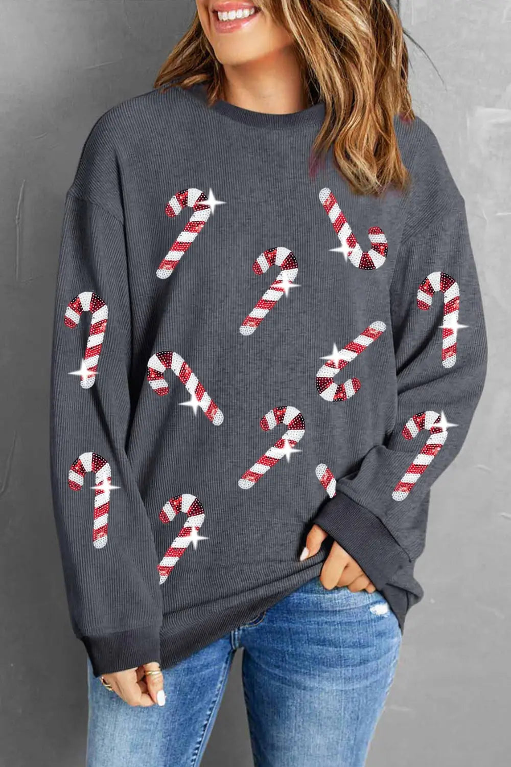 Gray sweater with red and white candy cane print, paired with blue jeans for festive holiday style.