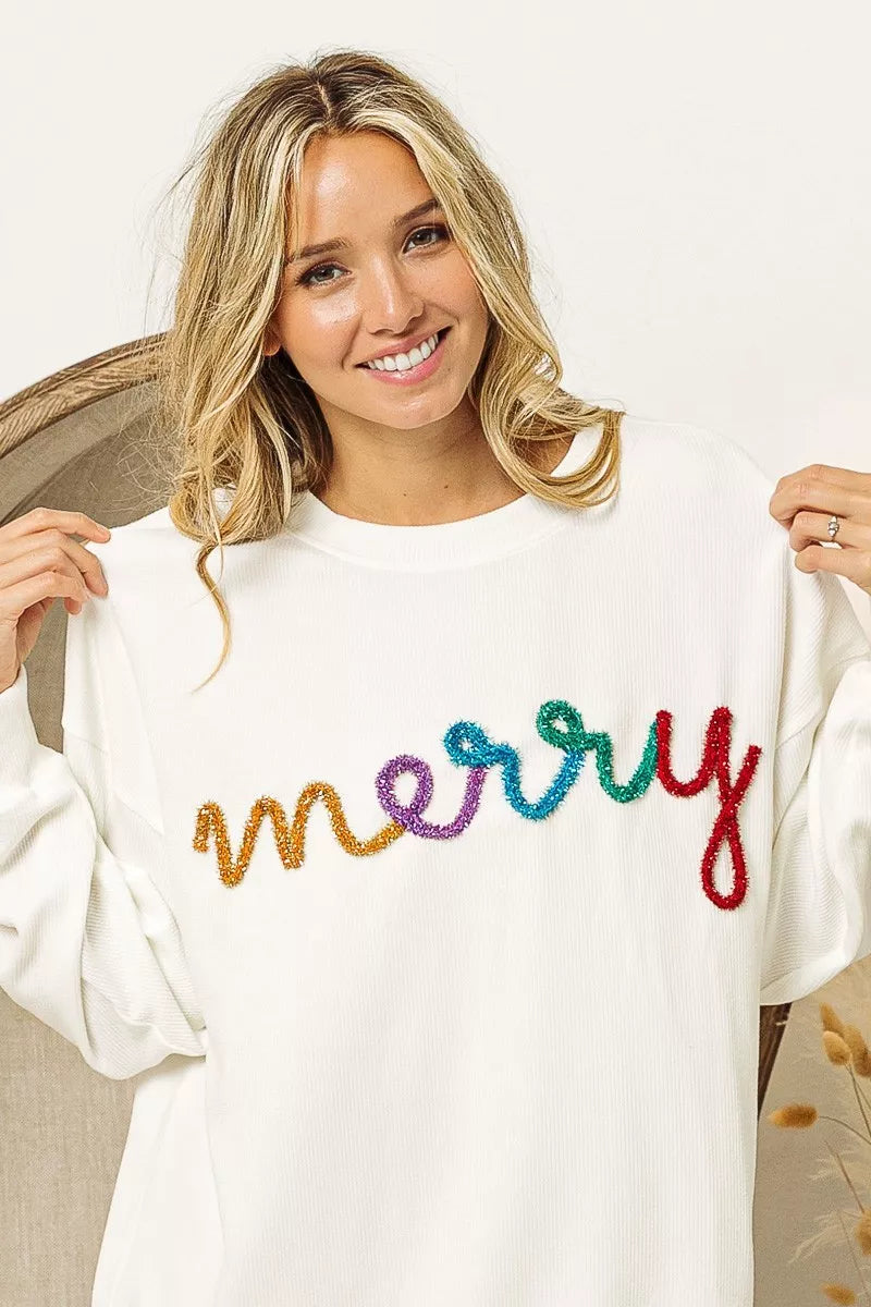 White cozy sweater with colorful 'merry' embroidery, perfect for festive women's fashion.