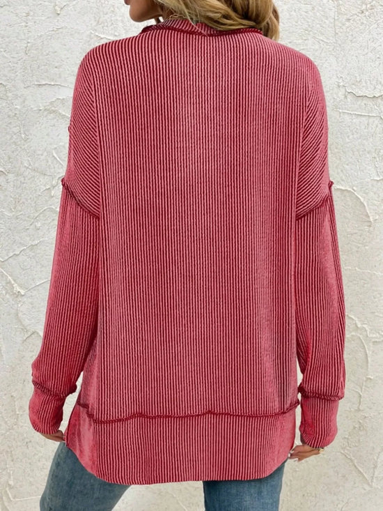 Red ribbed long-sleeve top with relaxed fit, paired with jeans for casual style